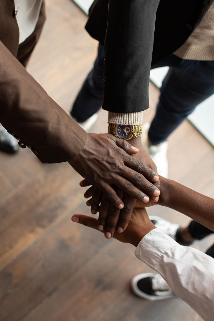 Services Diverse hands uniting in teamwork inside a professional office environment.